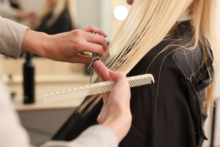 A small business owner at work, cutting hair in a studio